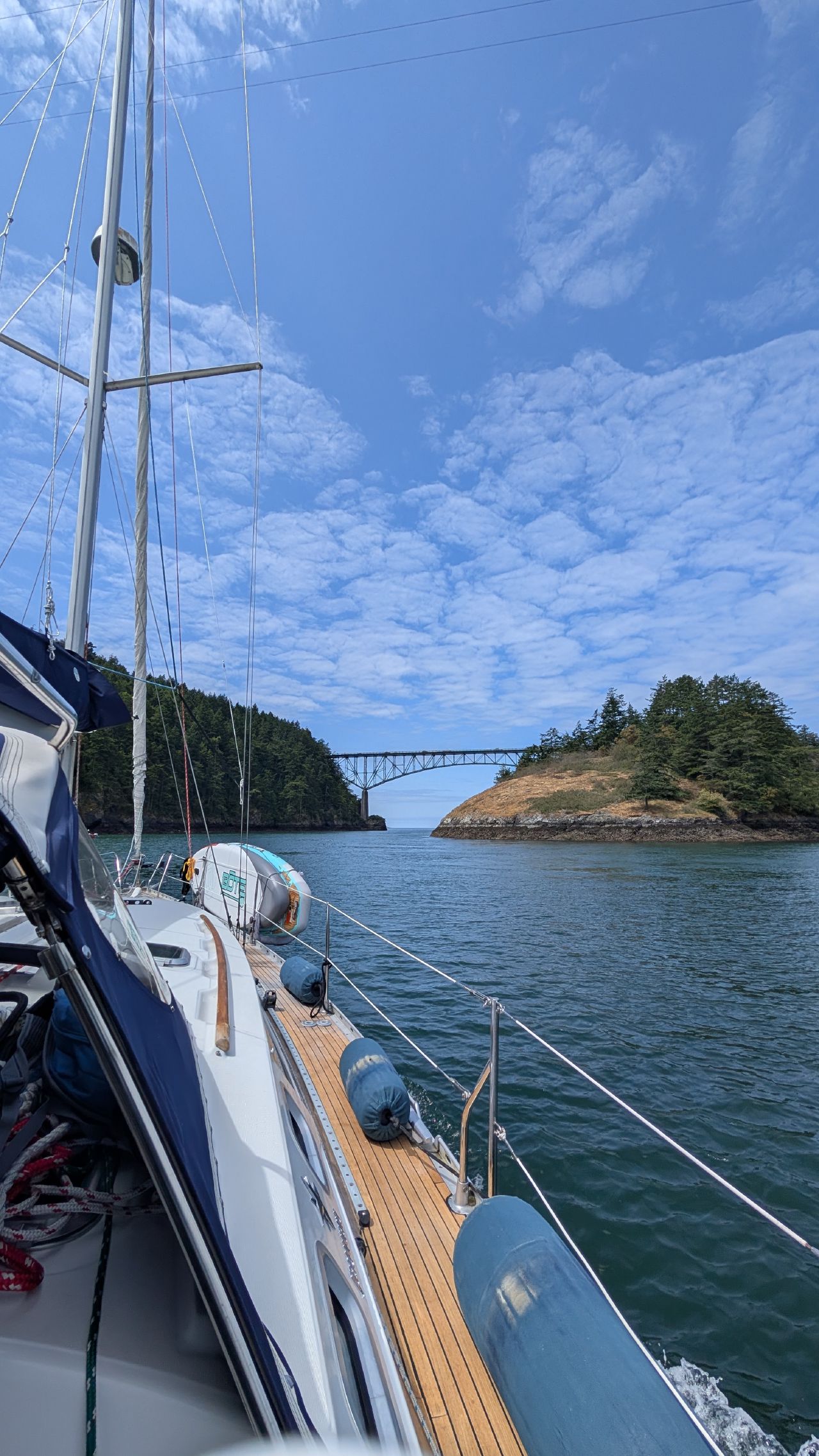 View from the teak deck of SV Yahara approaching Deception Pass Bridge on a sunny day