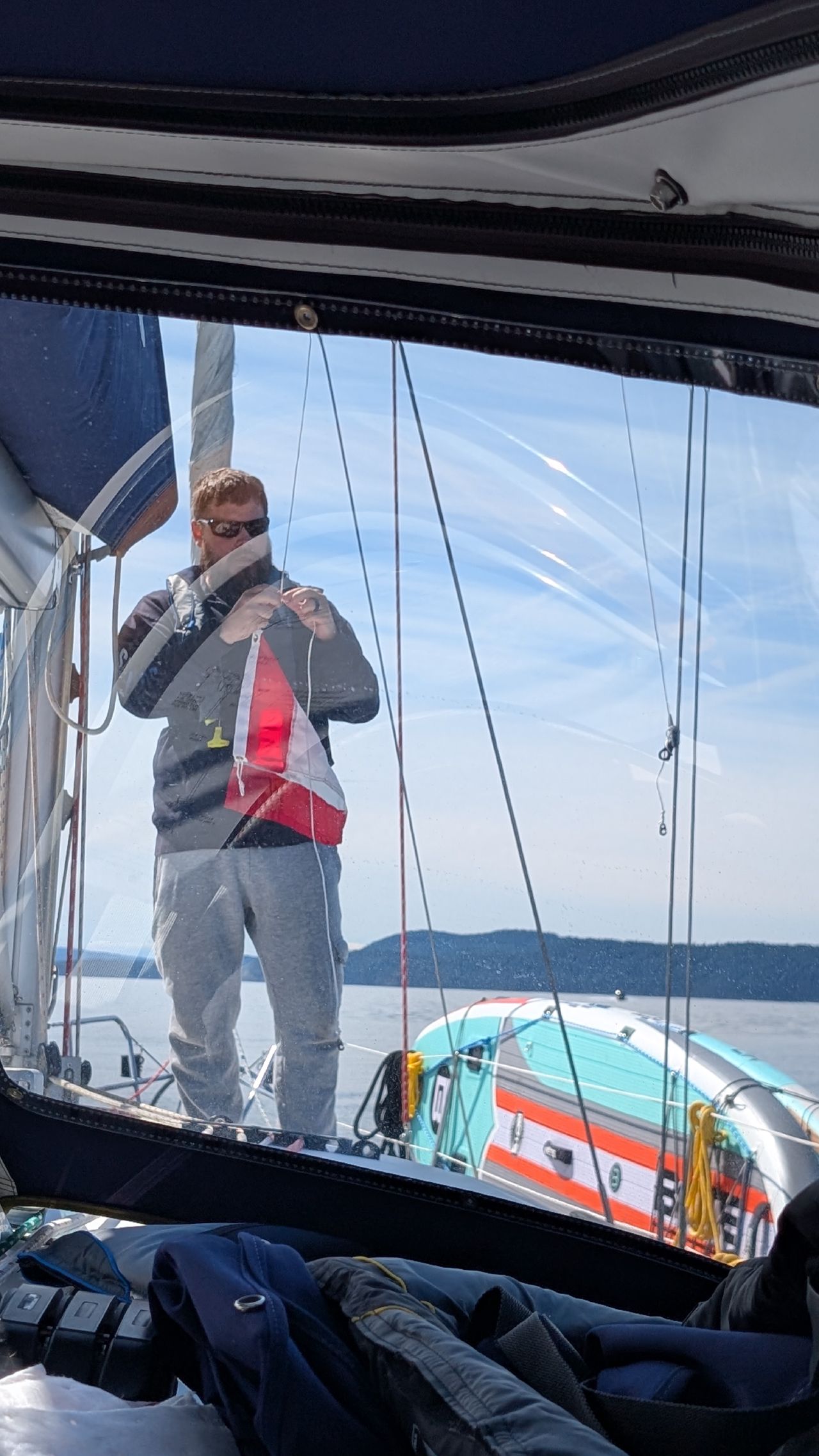 Brian raising the Canadian courtesy flag on SV Yahara after clearing customs into Canada