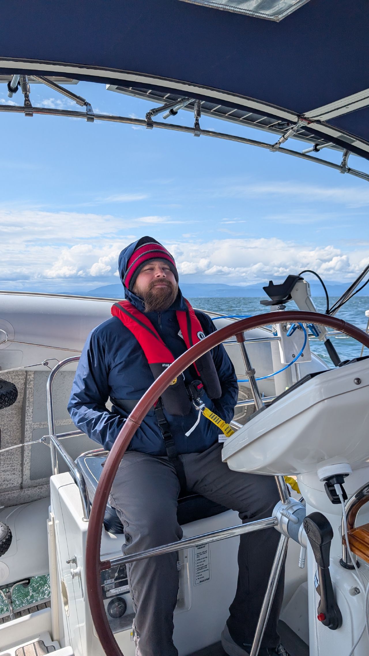 Brian bundled up at the helm in foul weather gear crossing the Strait of Georgia