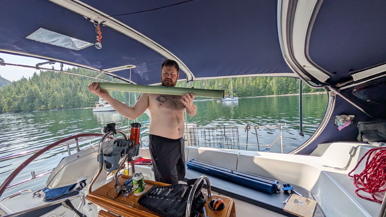Brian holding the new watermaker reverse osmosis membrane in the cockpit of SV Yahara