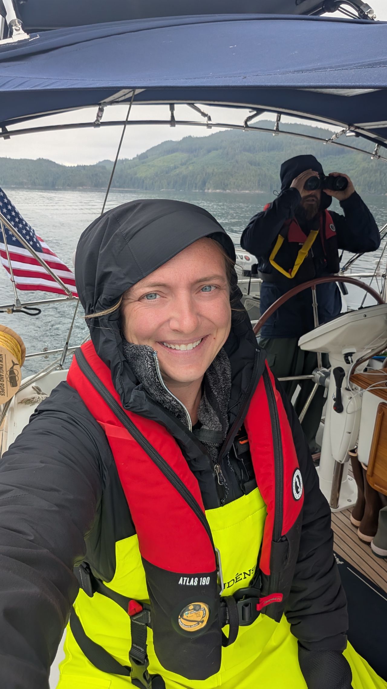 Rachel in high-visibility foul weather gear with Brian scanning for debris with binoculars