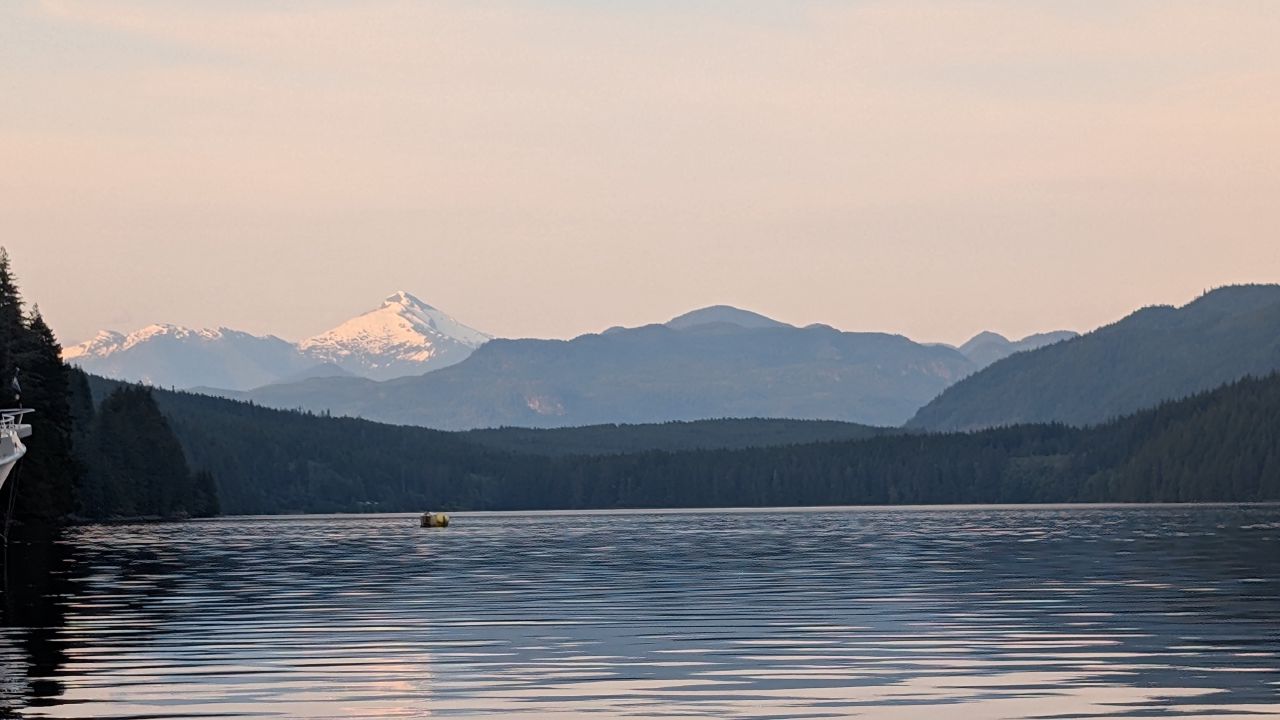 Snow-capped mountains glowing at sunset viewed from the anchorage at Forward Harbour