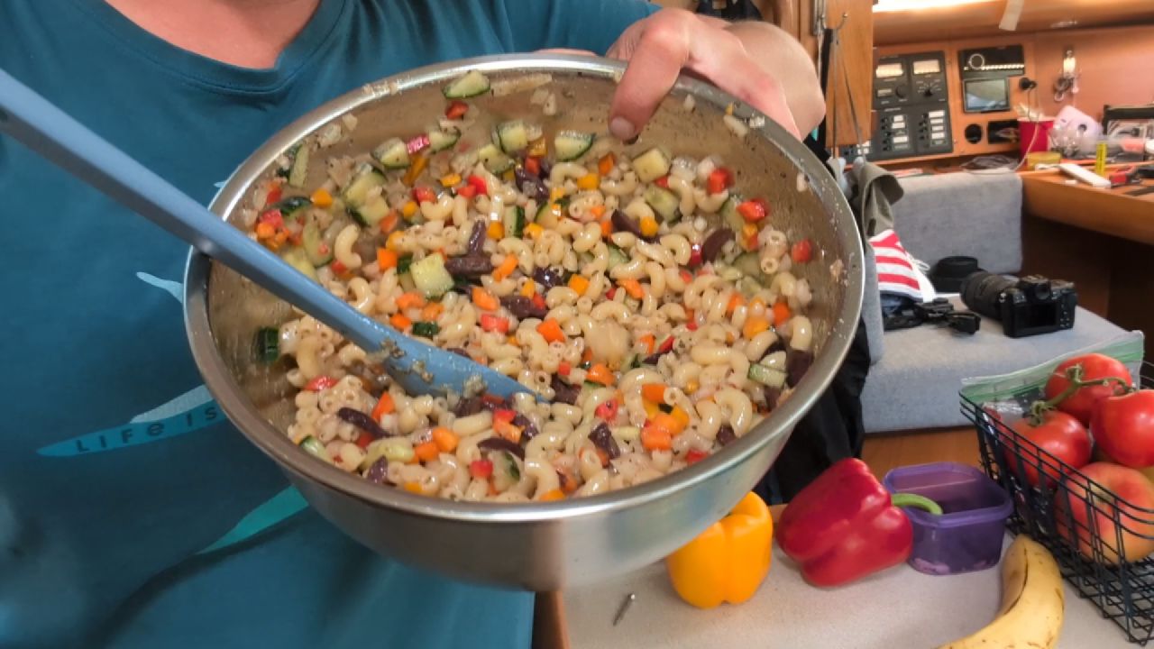 Rachel holding a big bowl of pasta salad made in the galley for the cruisers potluck