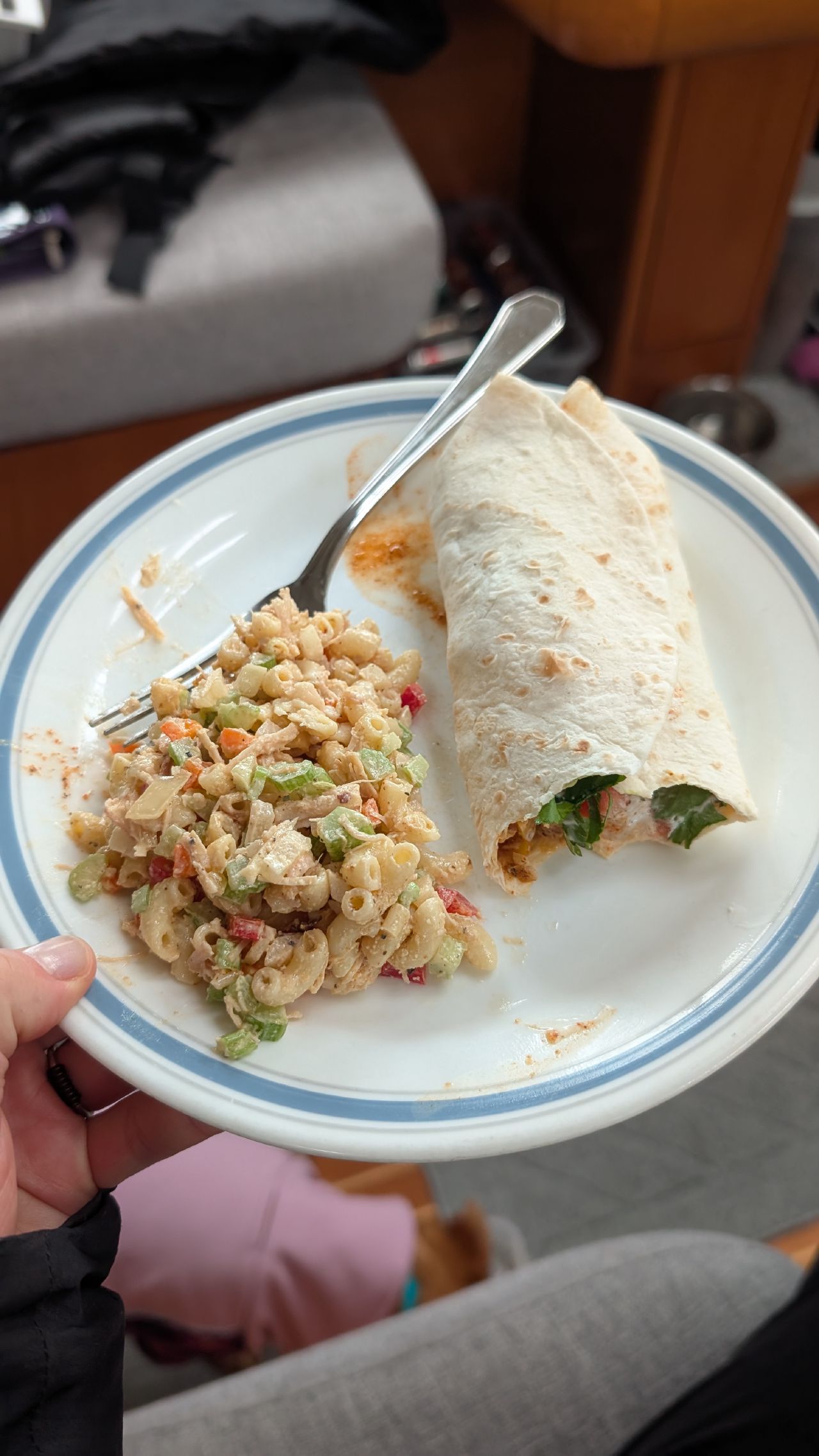 Lunch plate with a wrap and pasta salad inside the cabin of SV Yahara