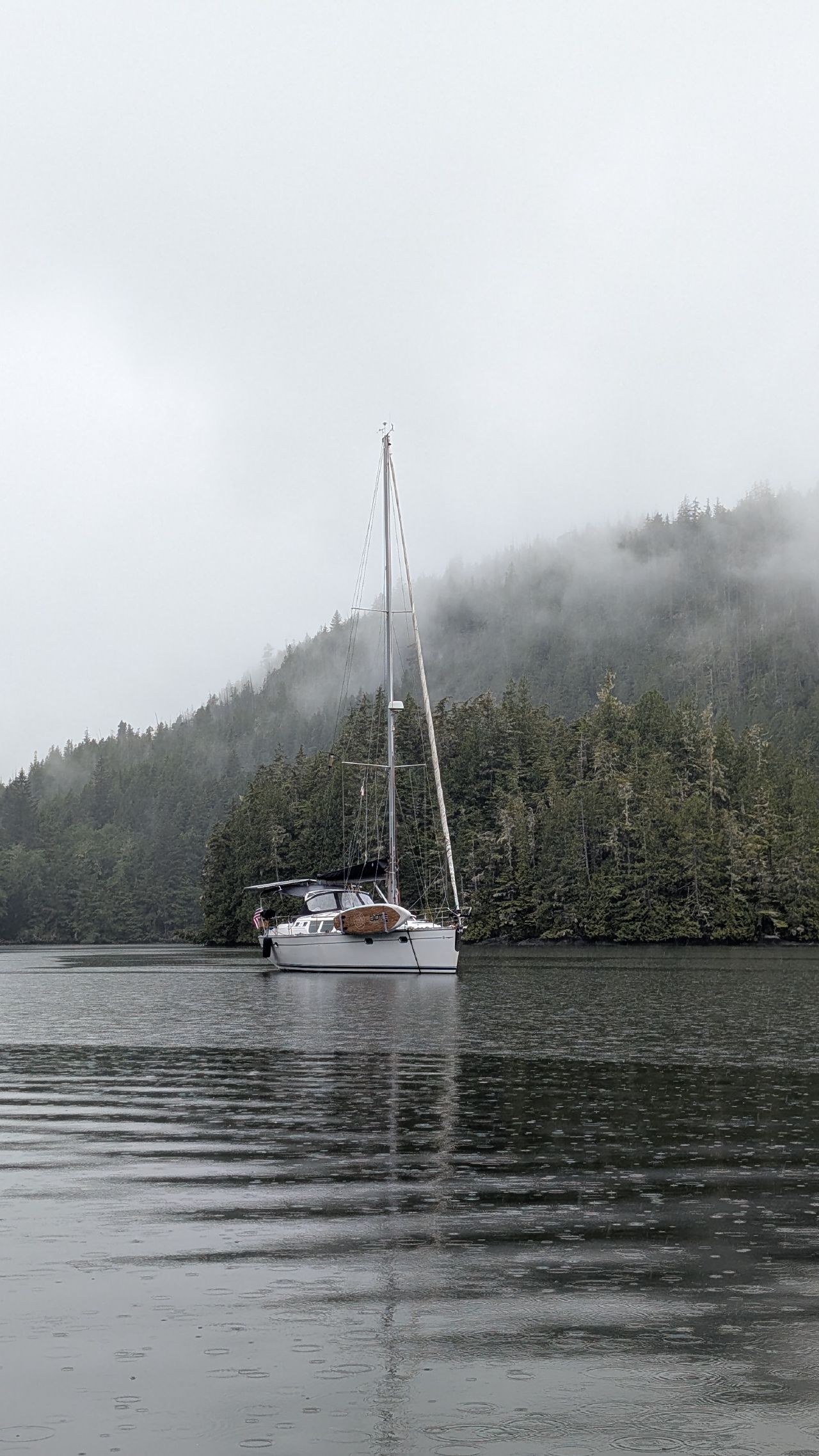 SV Yahara anchored alone in misty Waddington Bay with fog-covered mountains