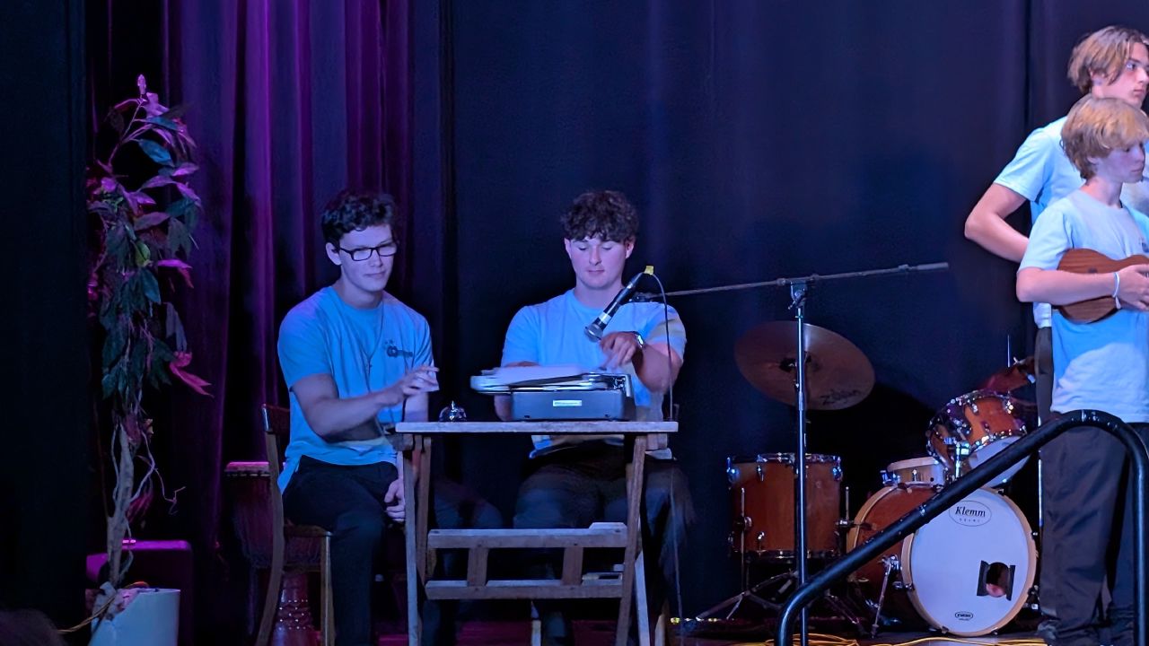 Students performing on a typewriter as an instrument during the ukulele concert