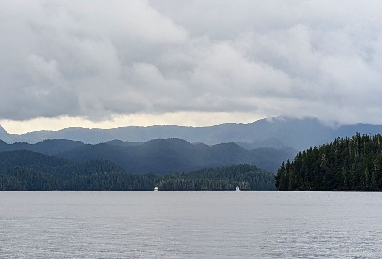 Layered misty mountains and calm waters on the passage to Pruth Bay