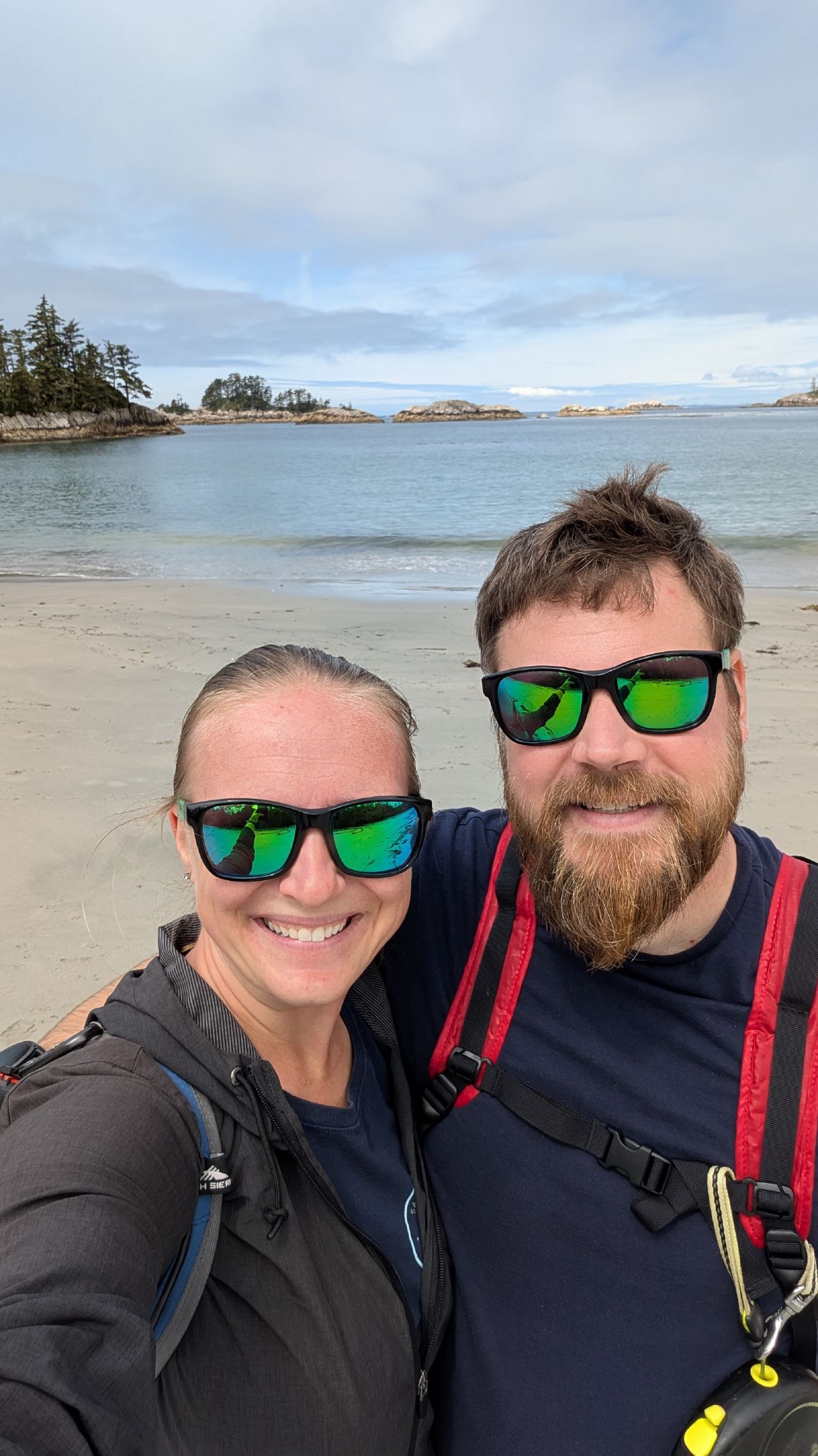 Rachel and Brian selfie with sunglasses on the beach at Pruth Bay with islands in the background