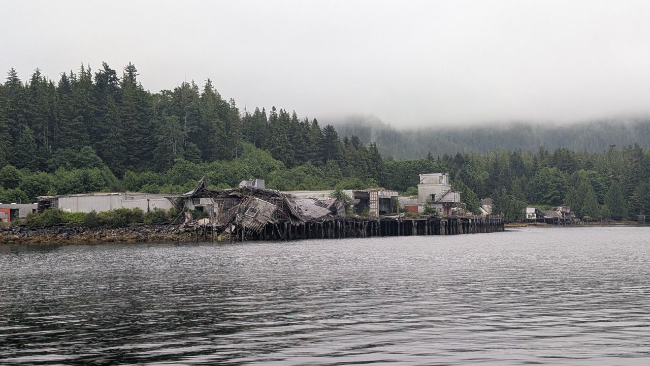 The abandoned Namu cannery buildings and collapsed docks seen from the water on a foggy day