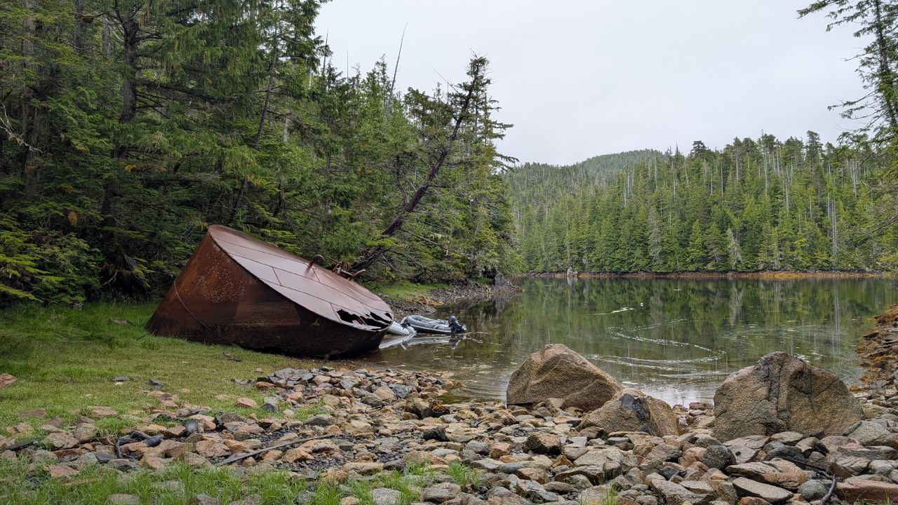 Large rusty boiler relic washed up on the rocky shore at Rock Inlet