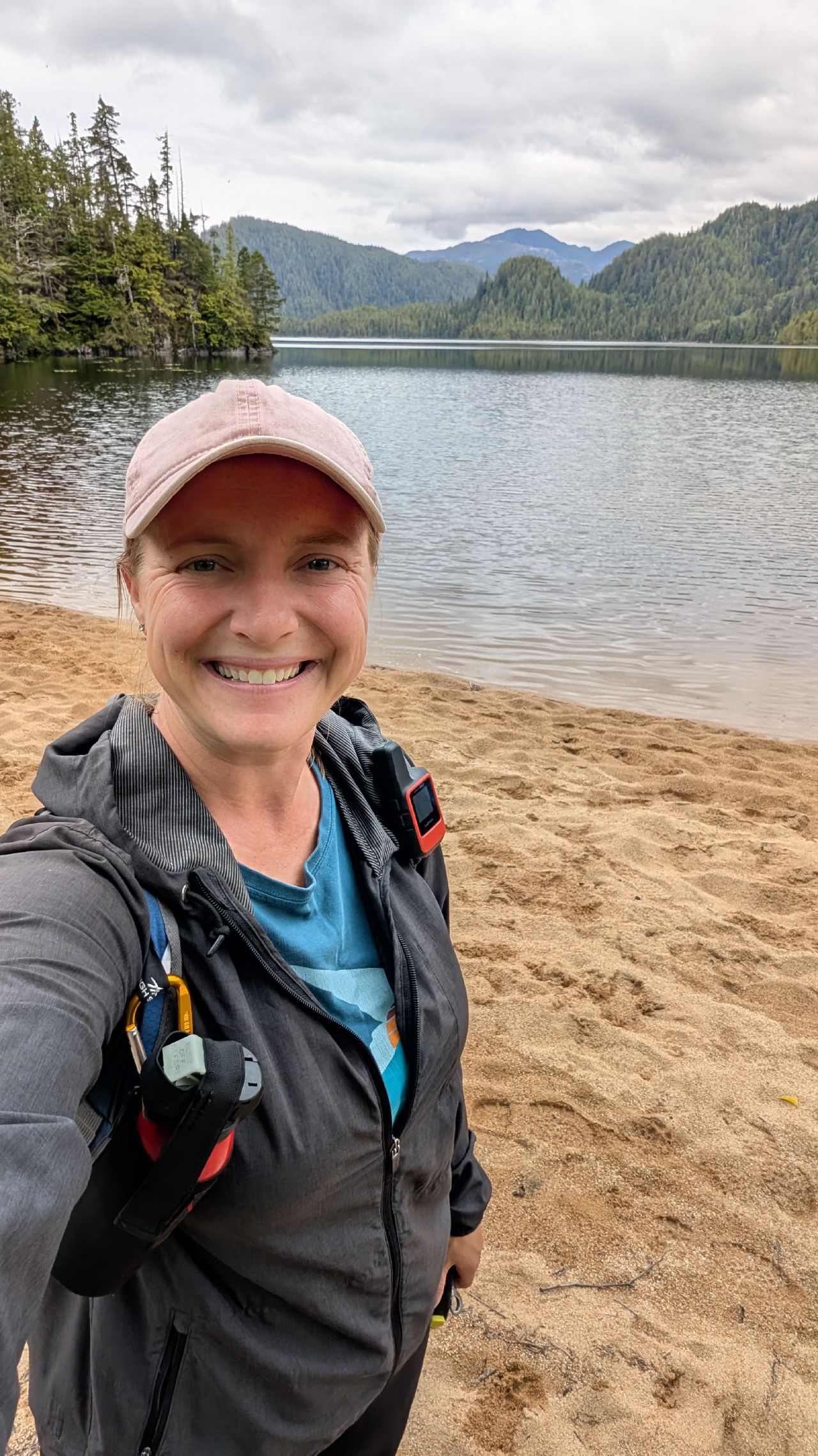 Rachel selfie at the sandy shore of a freshwater lake surrounded by mountains near Codville Lagoon