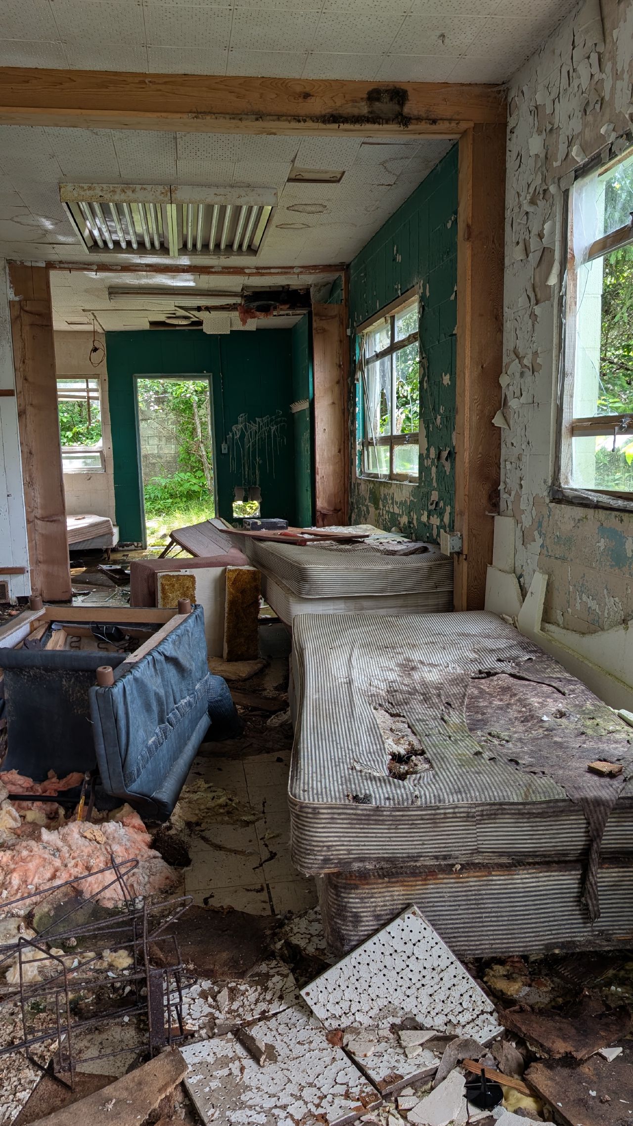 Abandoned dormitory room with rotting mattresses and peeling walls in Namu