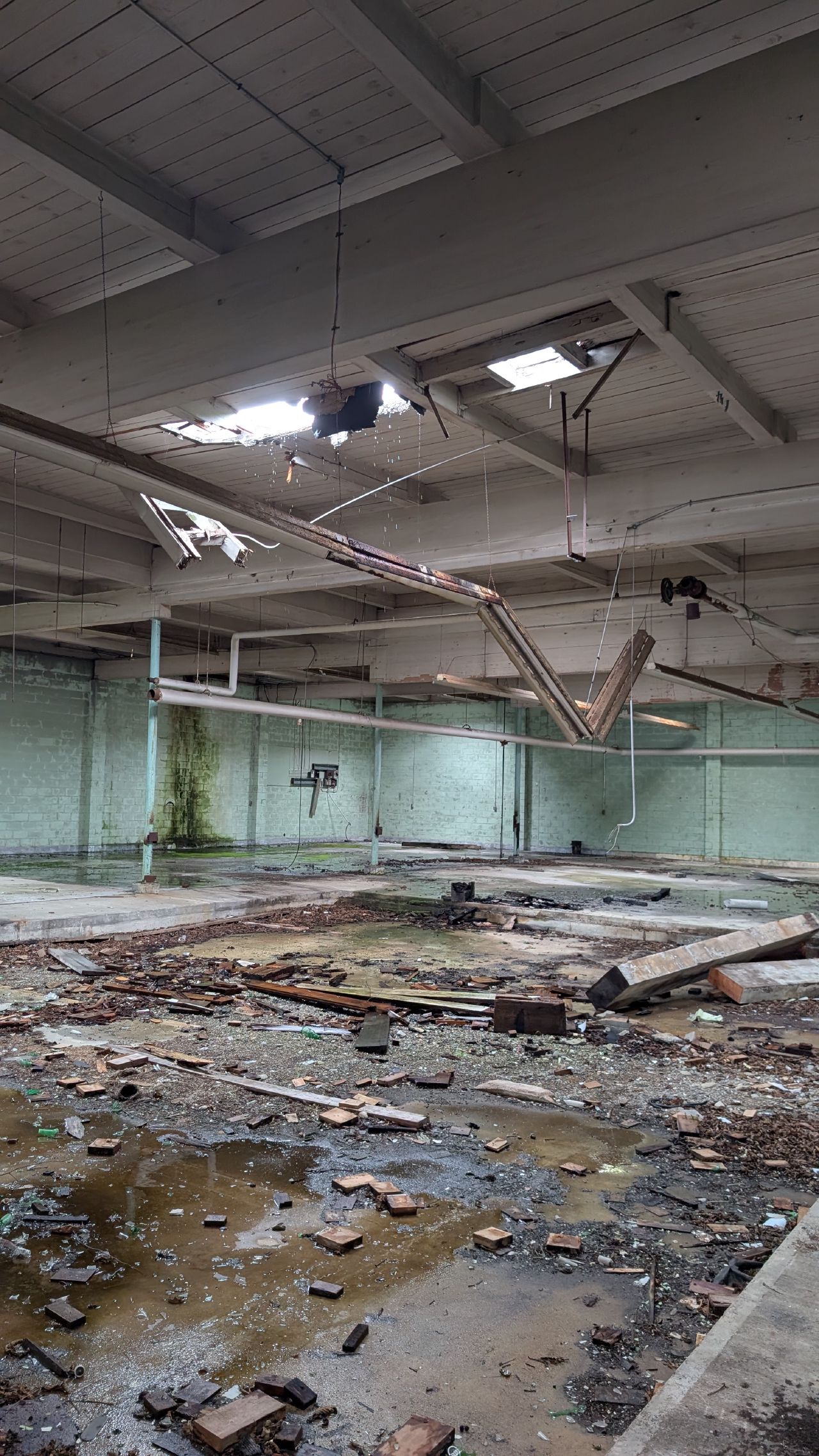 Collapsed ceiling and debris inside an abandoned cannery building in Namu