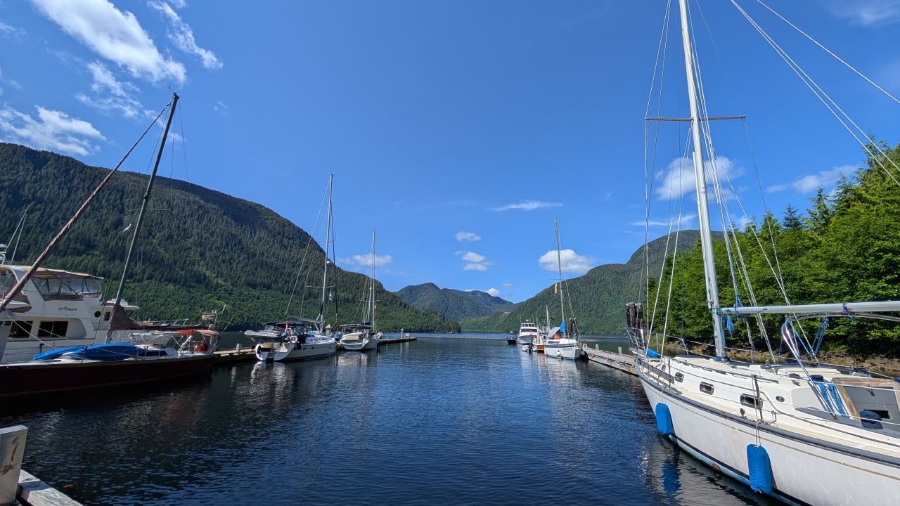 Boats docked at the Ocean Falls marina surrounded by steep forested mountains