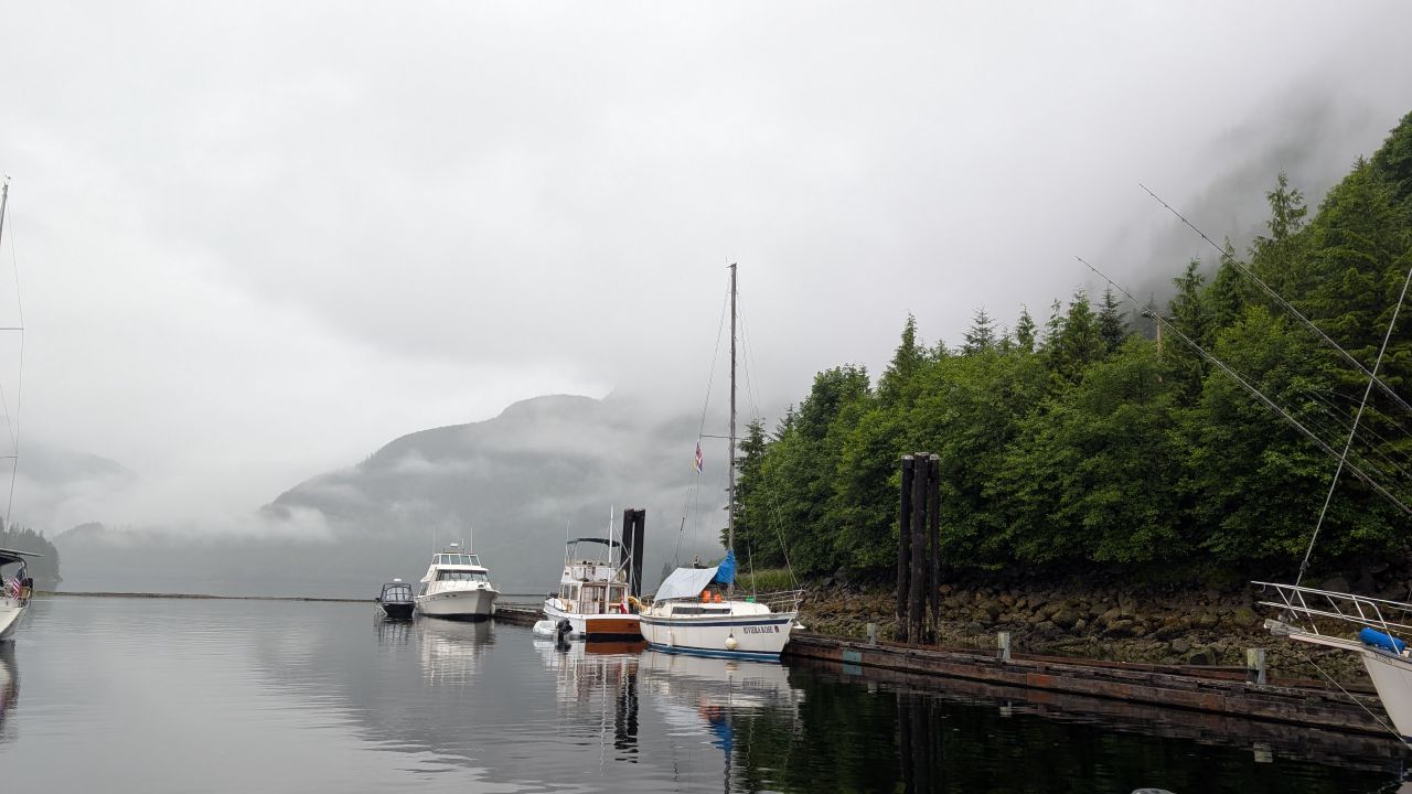 Ocean Falls marina on a foggy rainy day with low clouds covering the mountains