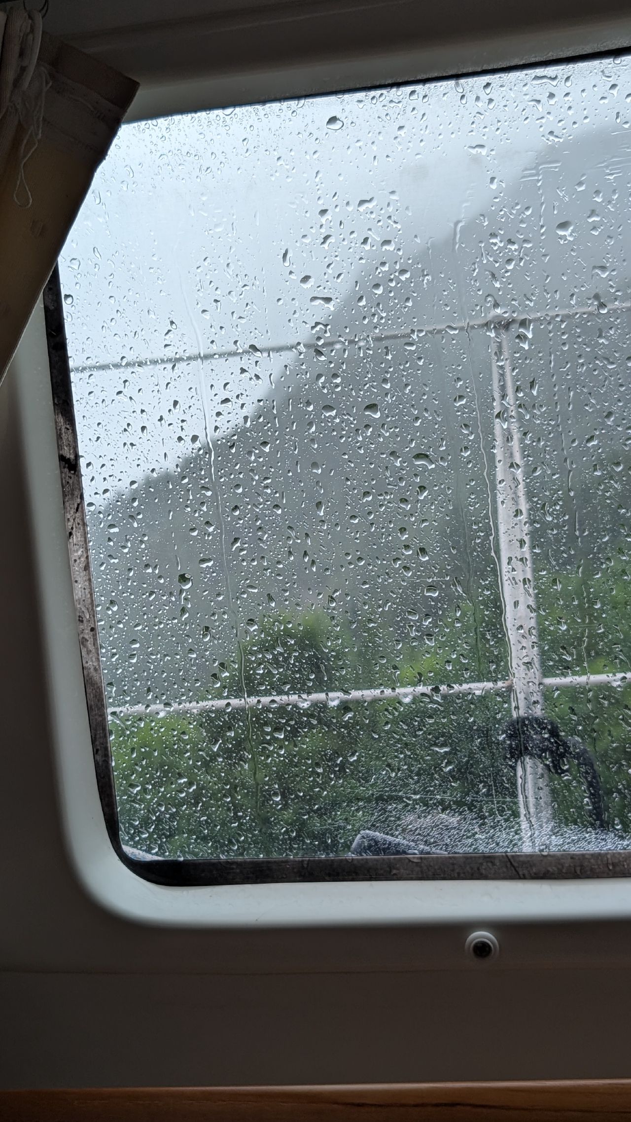 Heavy rain streaming down the porthole window while hunkered down at Ocean Falls