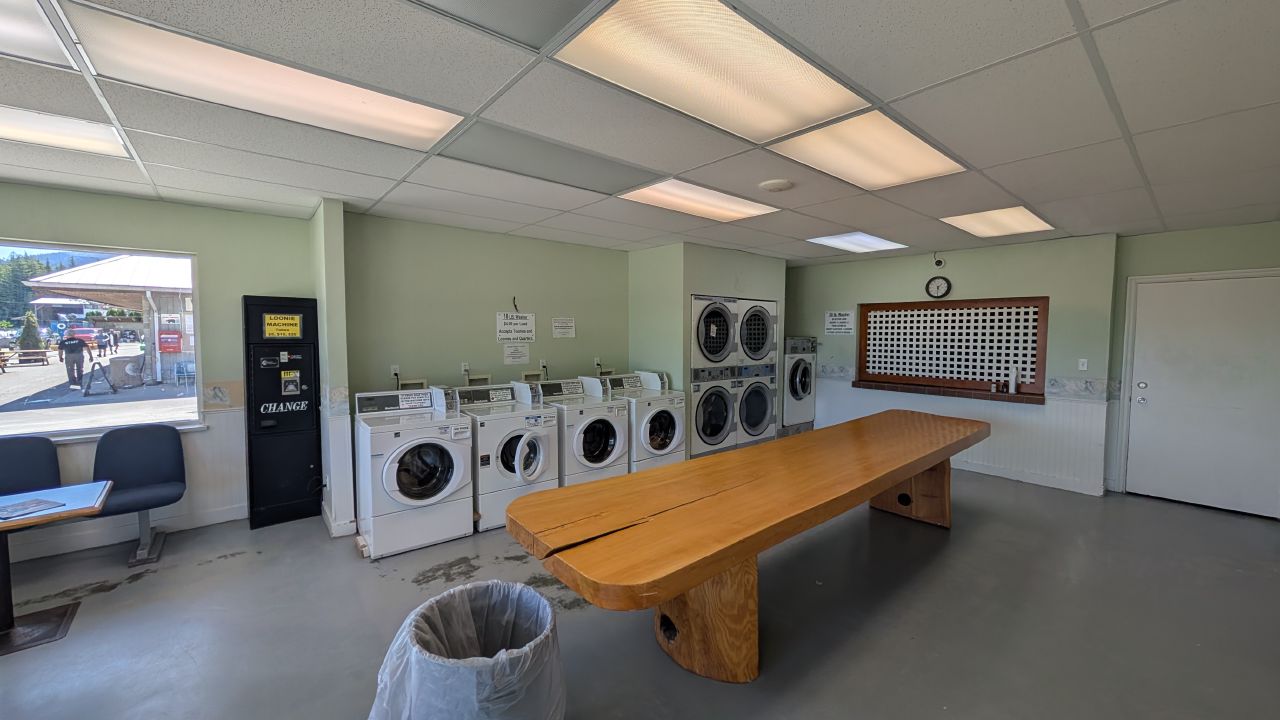 Inside the Shearwater laundromat with washers, dryers, and a large wooden slab bench
