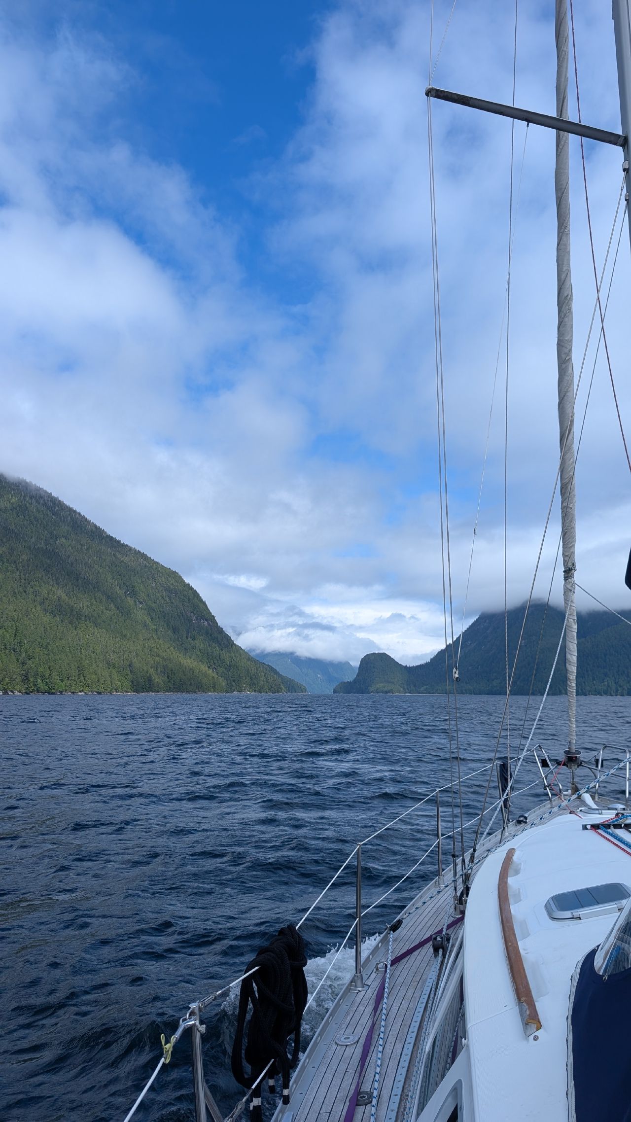 View from the deck of SV Yahara sailing through Mathison Channel with mountains and clouds ahead