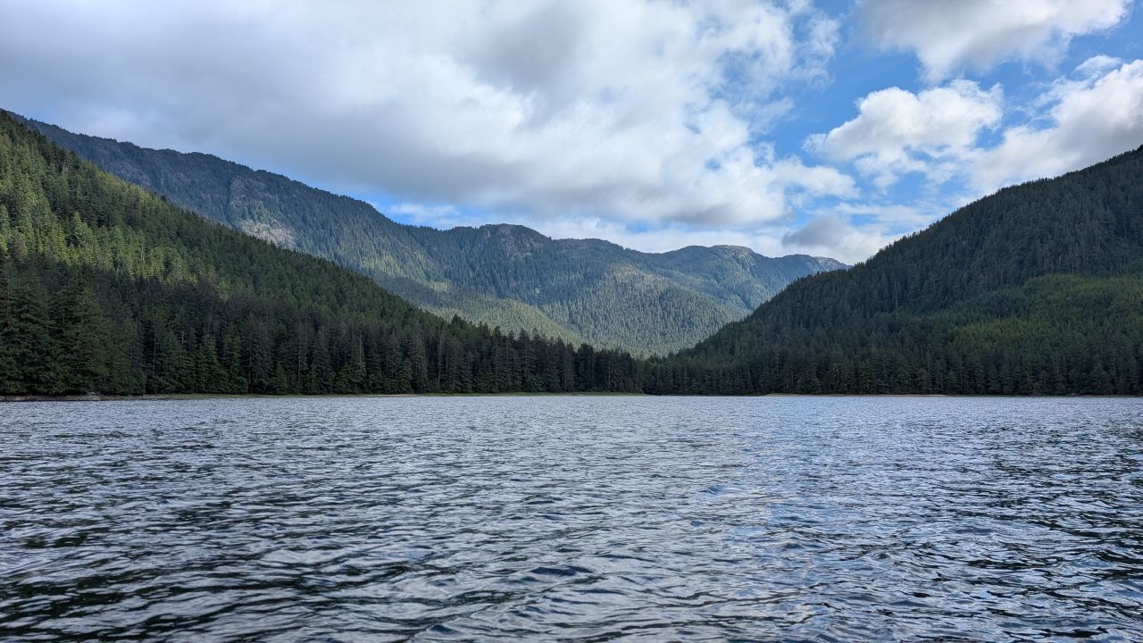 Panoramic view of forested mountains surrounding the calm waters of Windy Bay