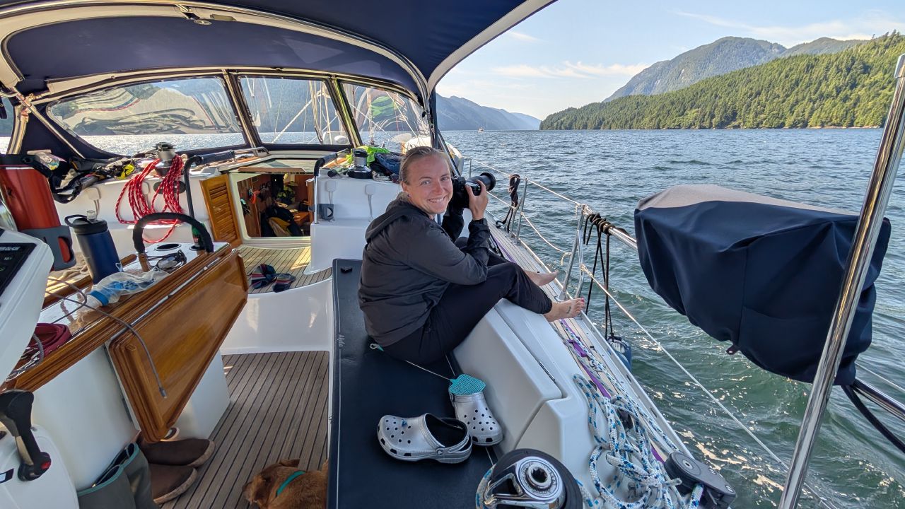 Rachel smiling with her camera in the cockpit, ready to photograph humpback whales on the passage to Butedale