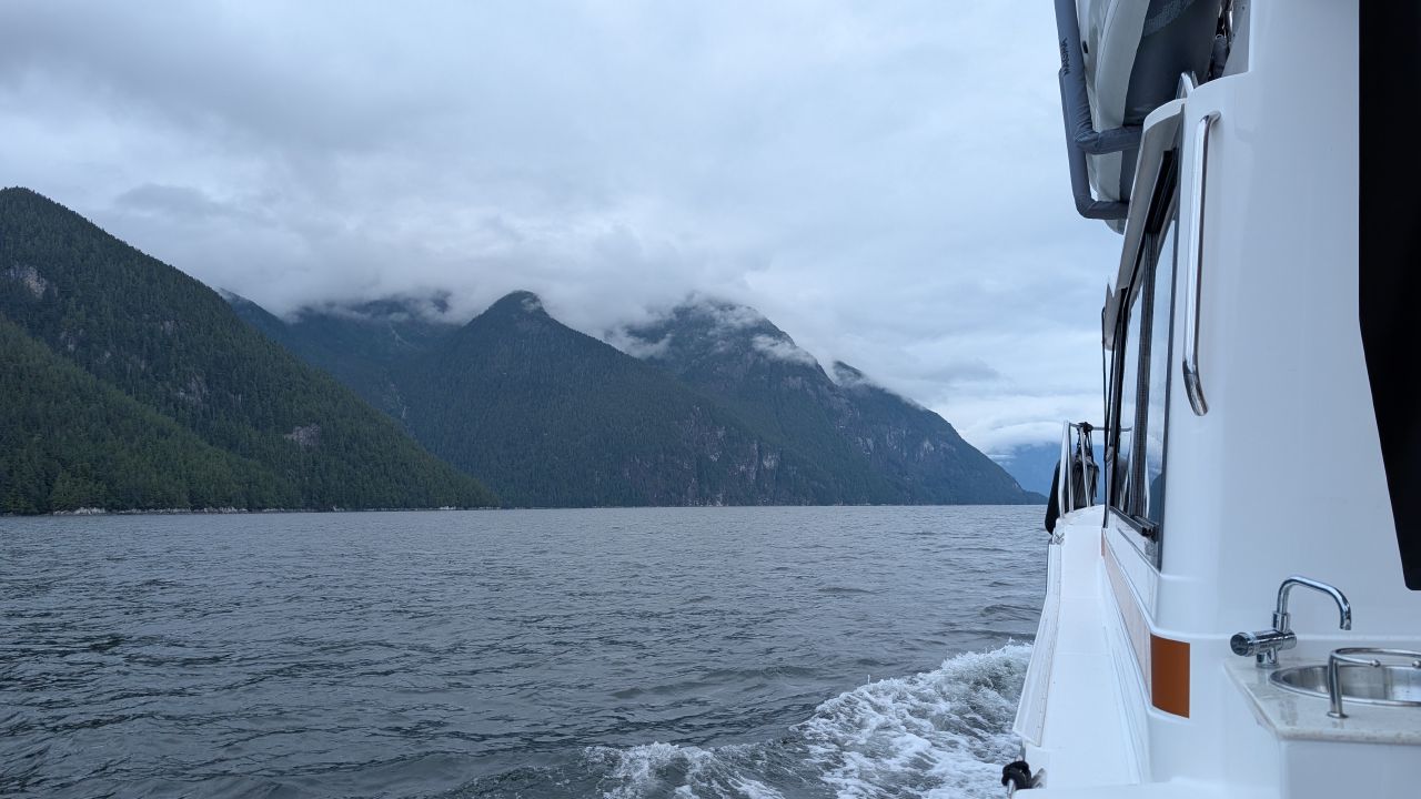 Cruising toward Poison Cove on a friend’s powerboat with cloud-covered mountains ahead