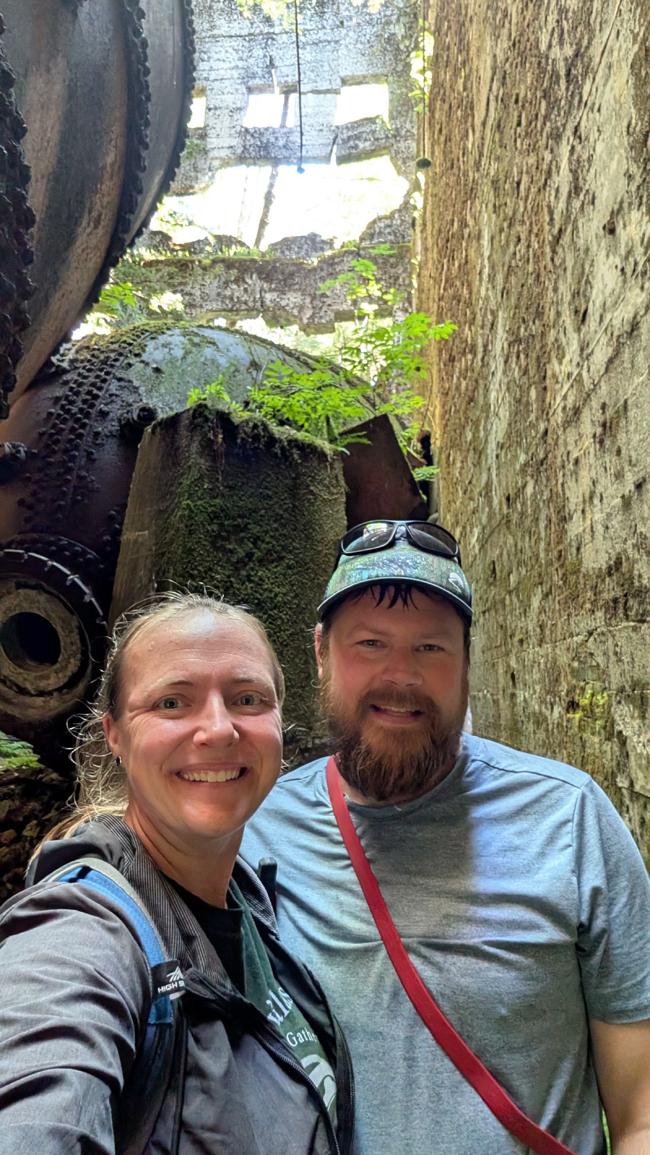 Rachel and Brian selfie surrounded by rusted industrial machinery at the Swanson Bay ruins