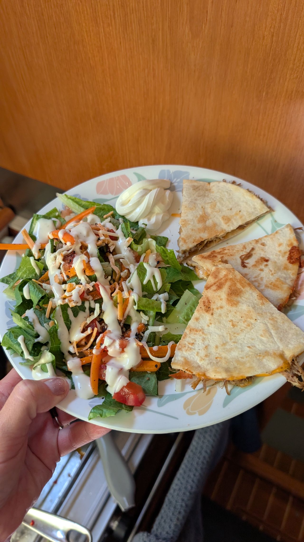 Pulled pork quesadilla with a fresh salad on a plate in the boat galley
