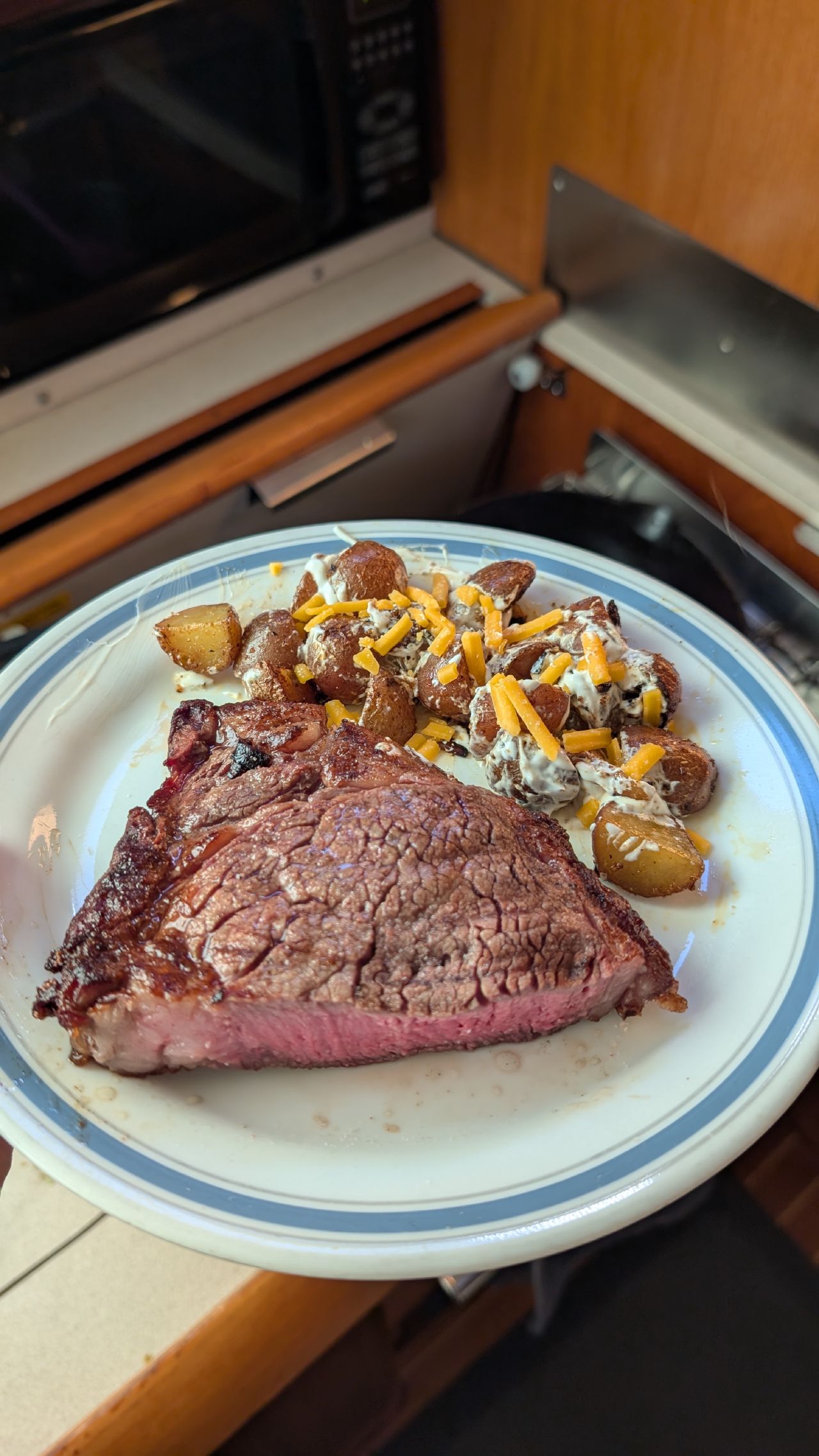 Seared steak with loaded potatoes and cheese dinner made in the boat galley