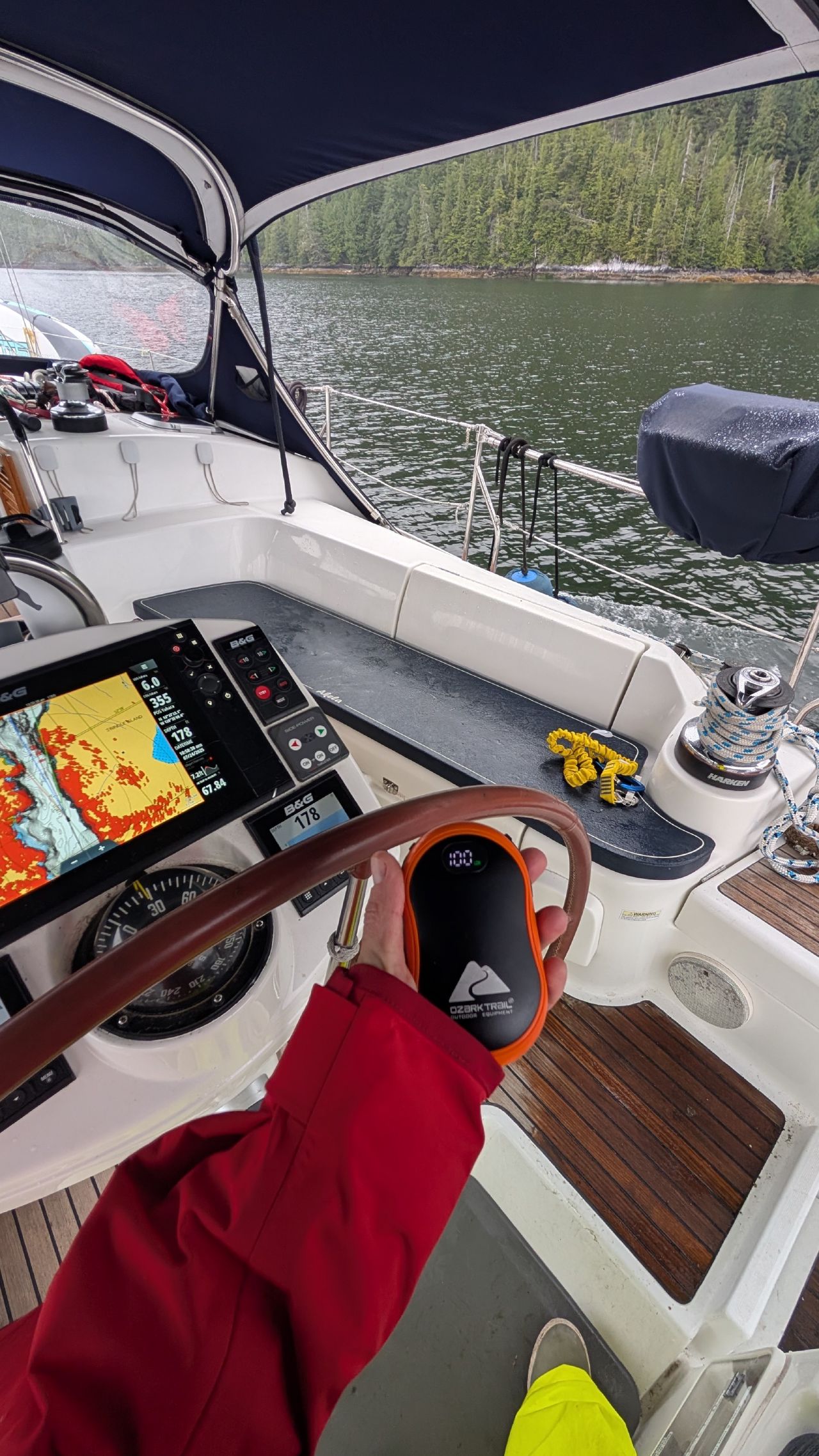 Hand warmer in hand at the helm with the chartplotter showing Meyers Pass navigation