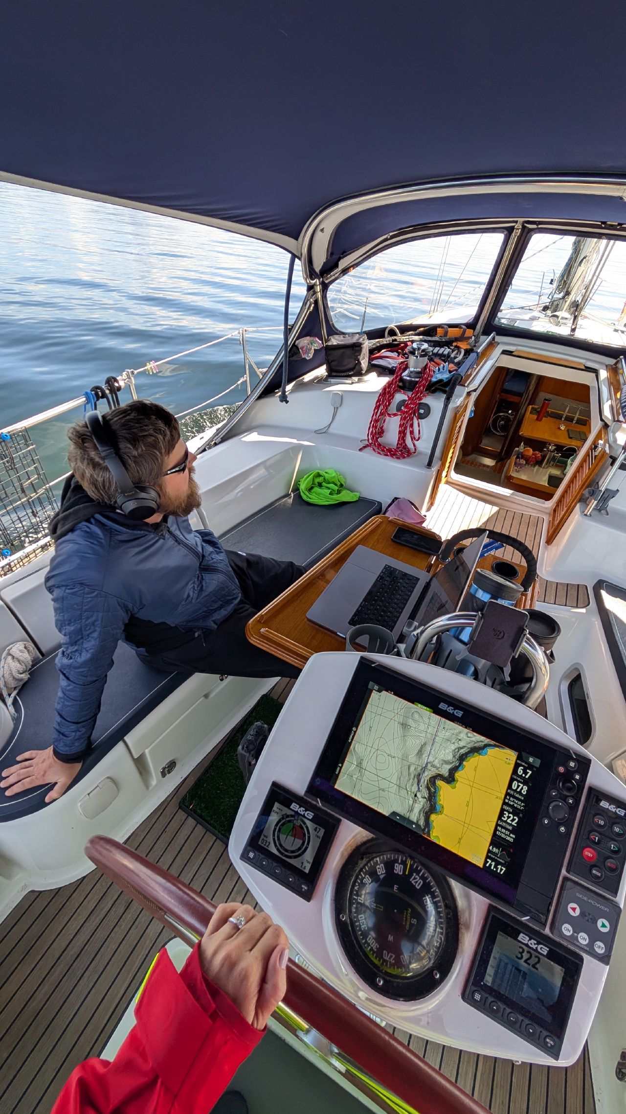Brian working on his laptop with headphones in the cockpit while Rachel steers