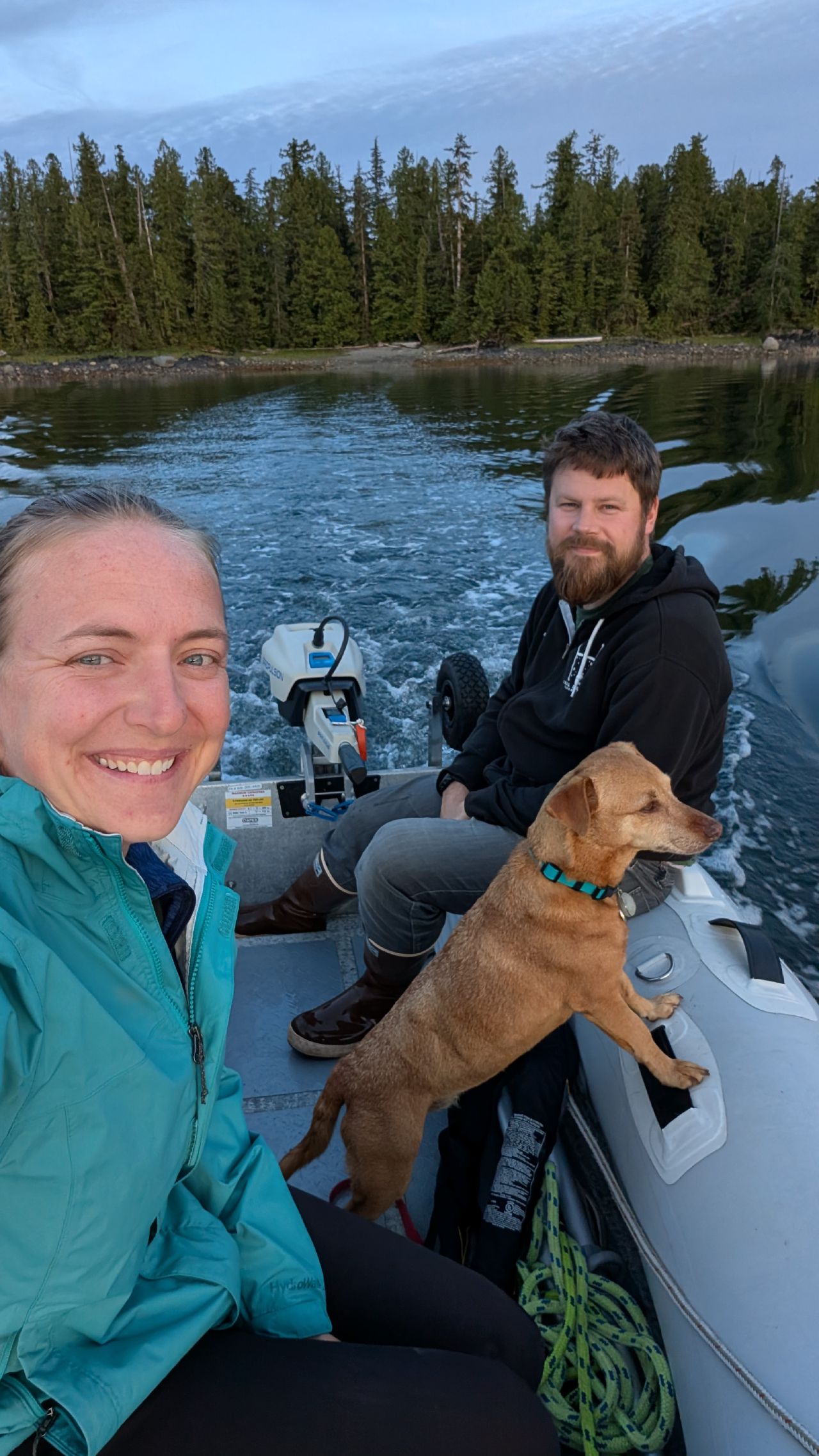 Rachel, Brian, and Maui taking a selfie in the dinghy heading to shore at sunset