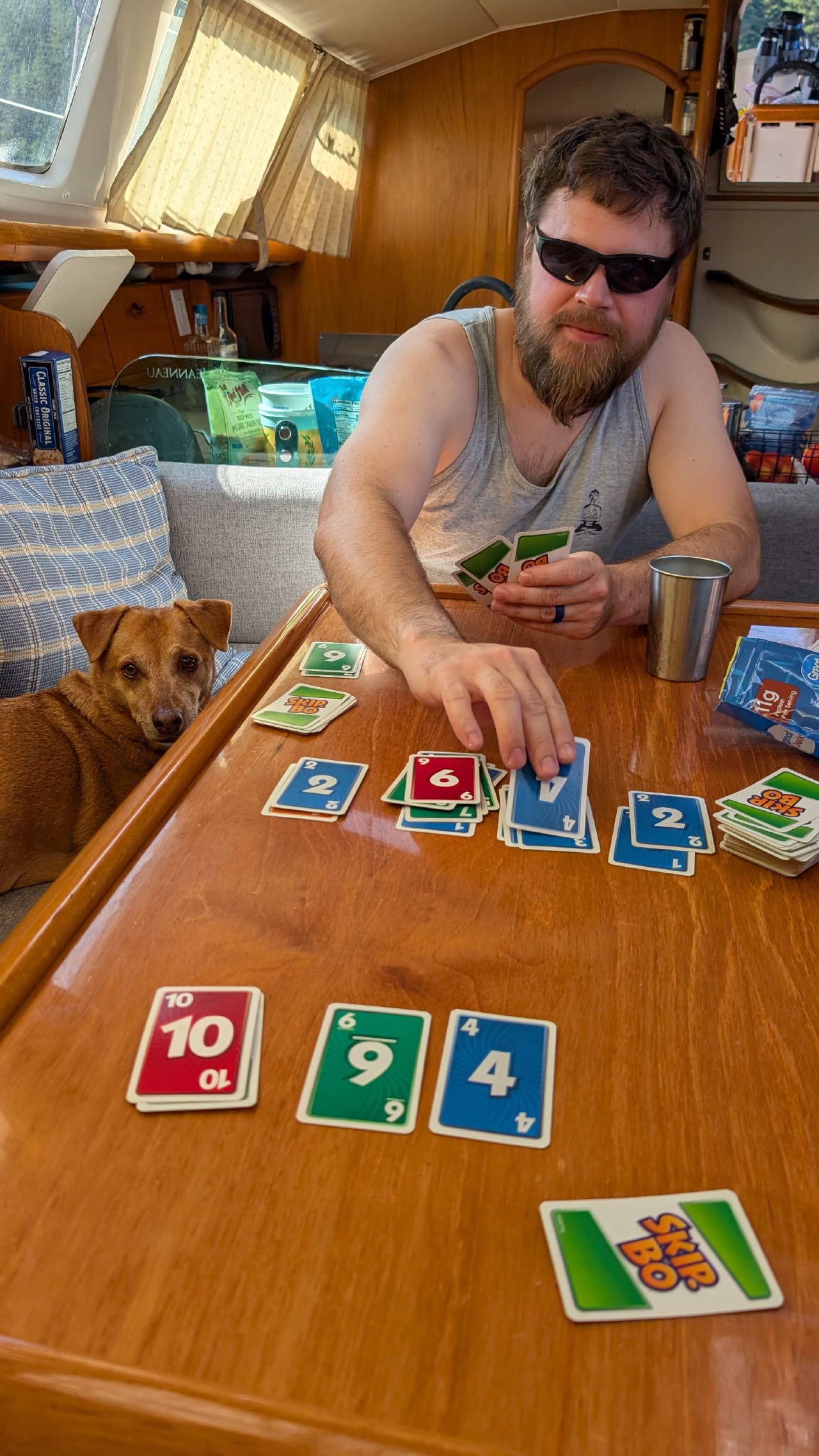 Brian playing Skip-Bo at the saloon table with Maui watching from the settee on a lazy Saturday