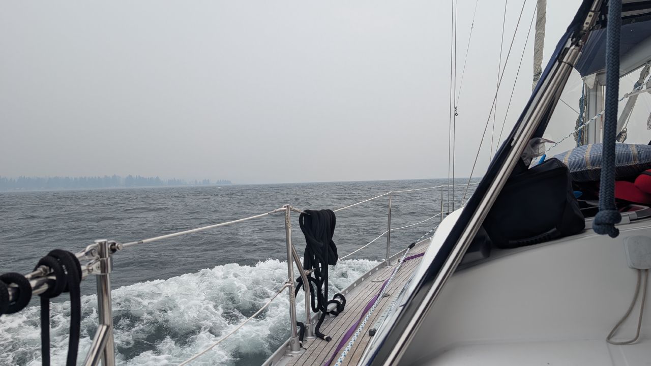 Rough seas and heavy spray along the deck of SV Yahara in 25-knot winds and smoky skies heading to Comox