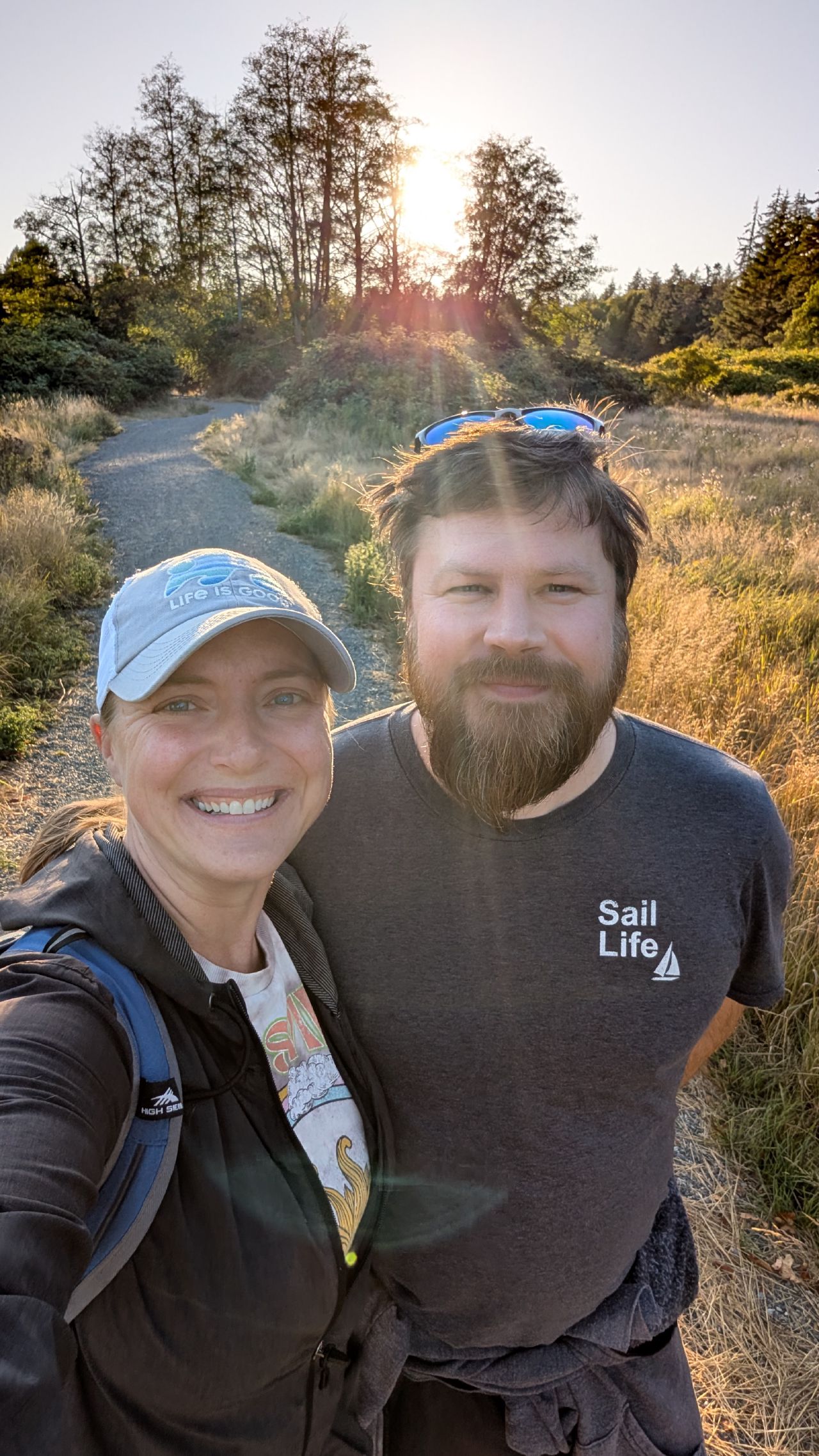 Rachel and Brian selfie on a golden hour hike on Hornby Island with sun setting through the trees