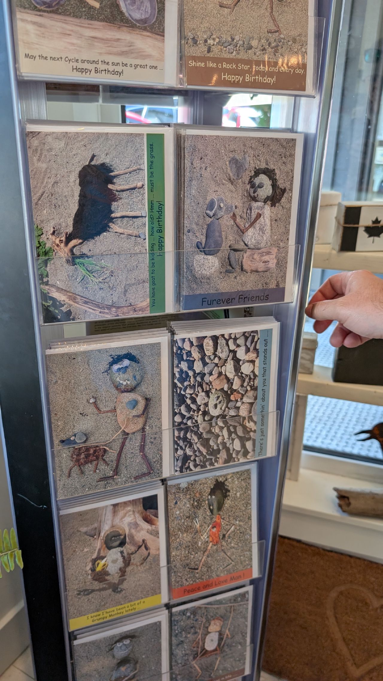 Display rack of locally made art cards with whimsical rock and driftwood designs at the Ladysmith makers market
