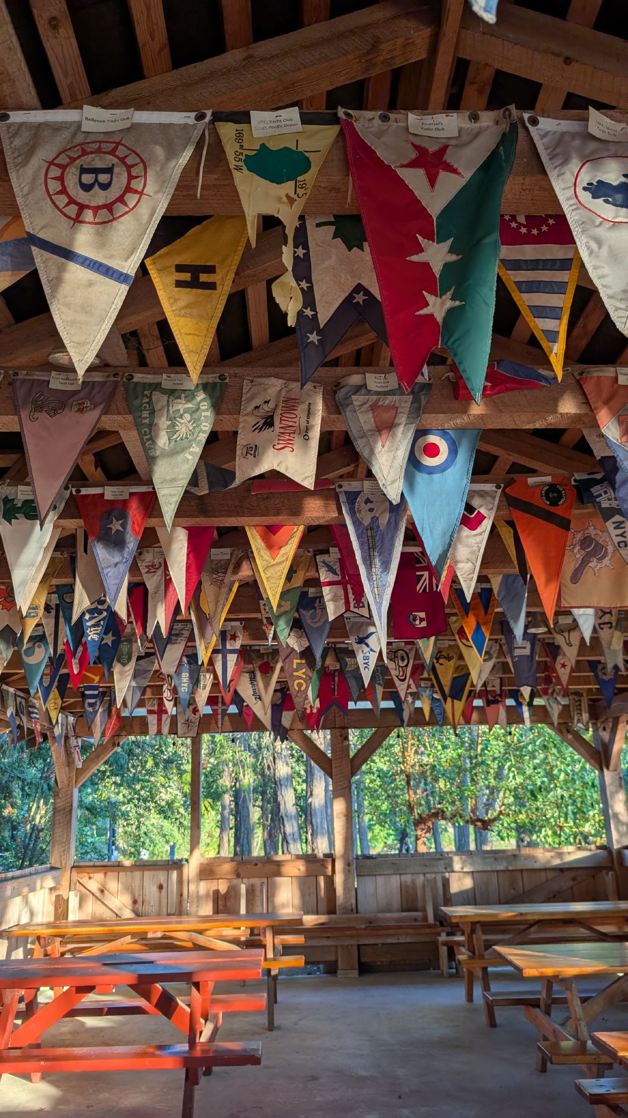 Colorful yacht club burgees hanging from the wooden rafters of the Telegraph Harbour pavilion