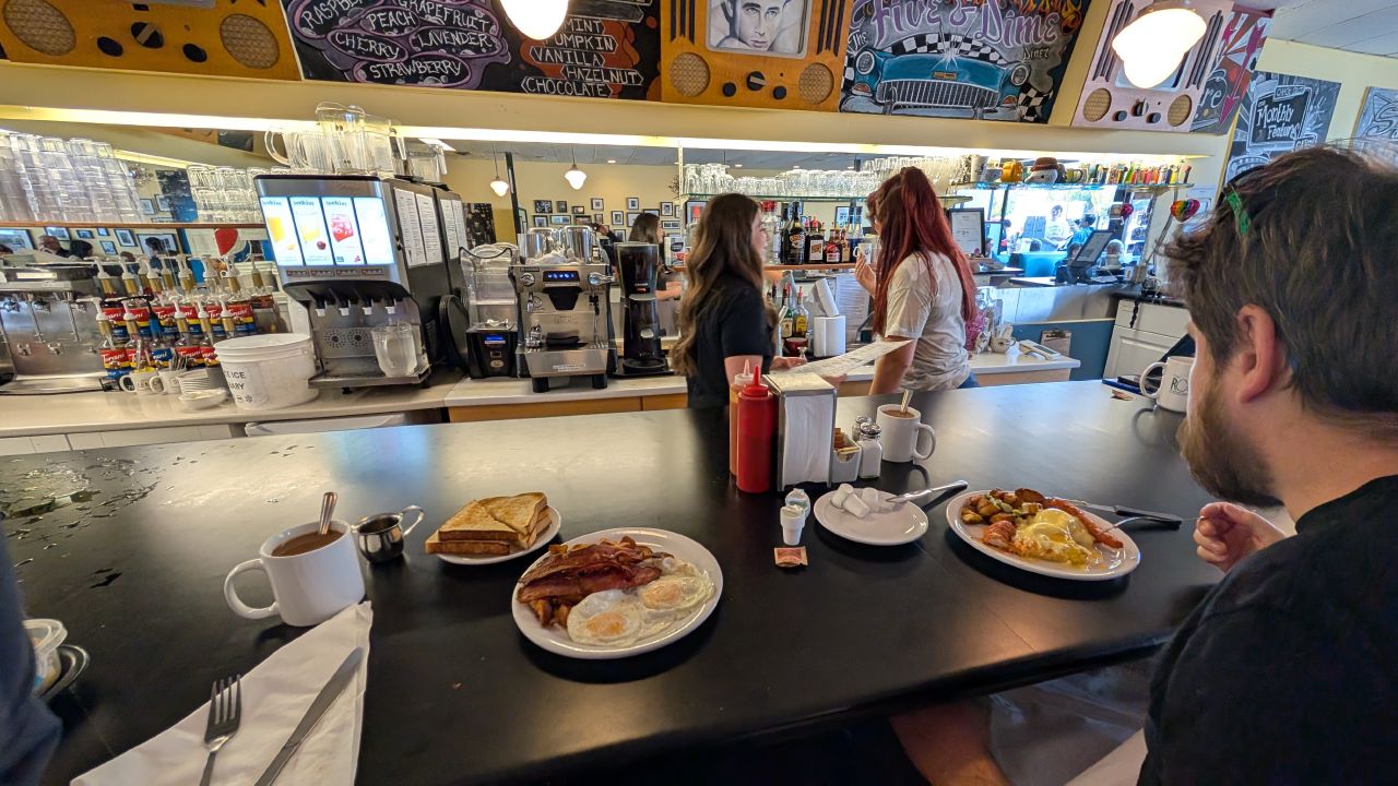 Breakfast plates with eggs, bacon, and toast at the Five and Dime Diner counter in Sidney