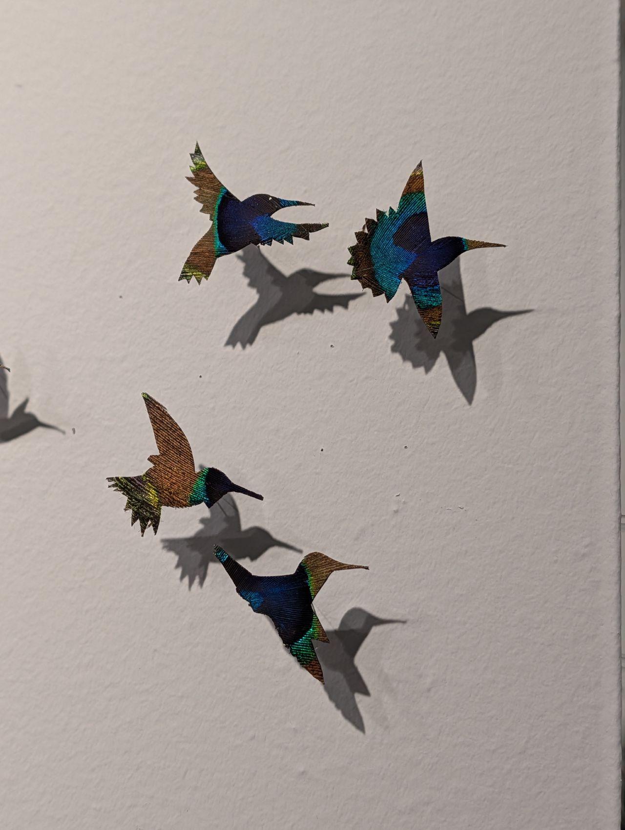Close-up of iridescent cut-paper hummingbird artwork