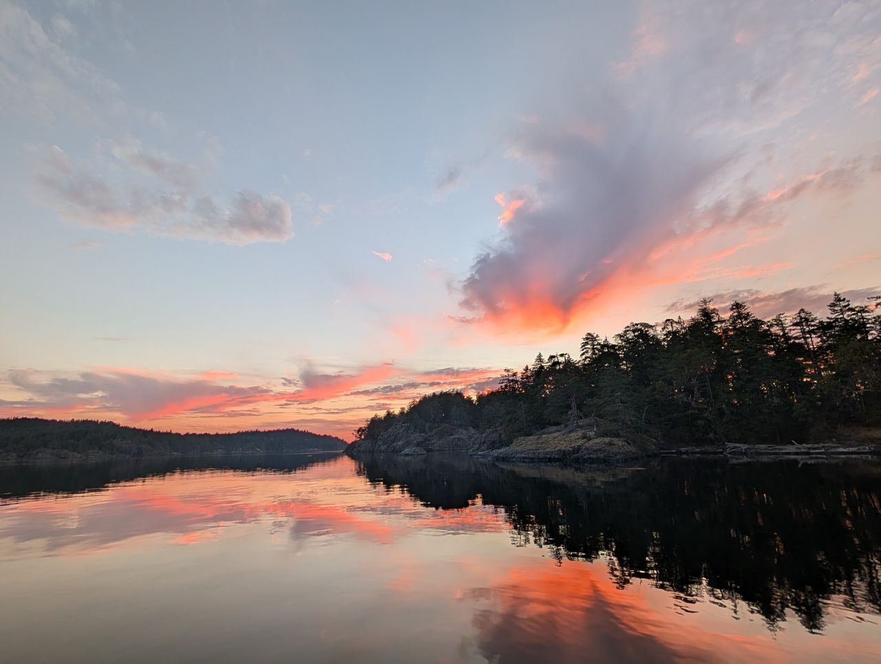 Pink and orange sunset reflected on the calm anchorage water