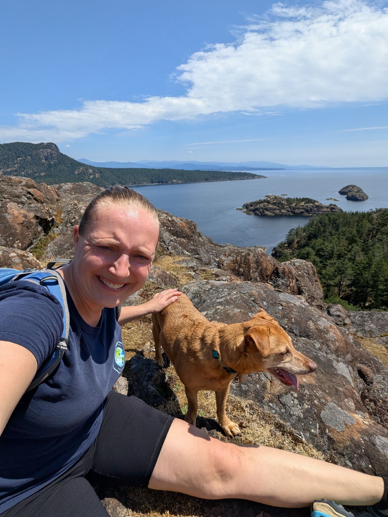 43% 63% Rachel and Maui on a rocky summit overlooking the water