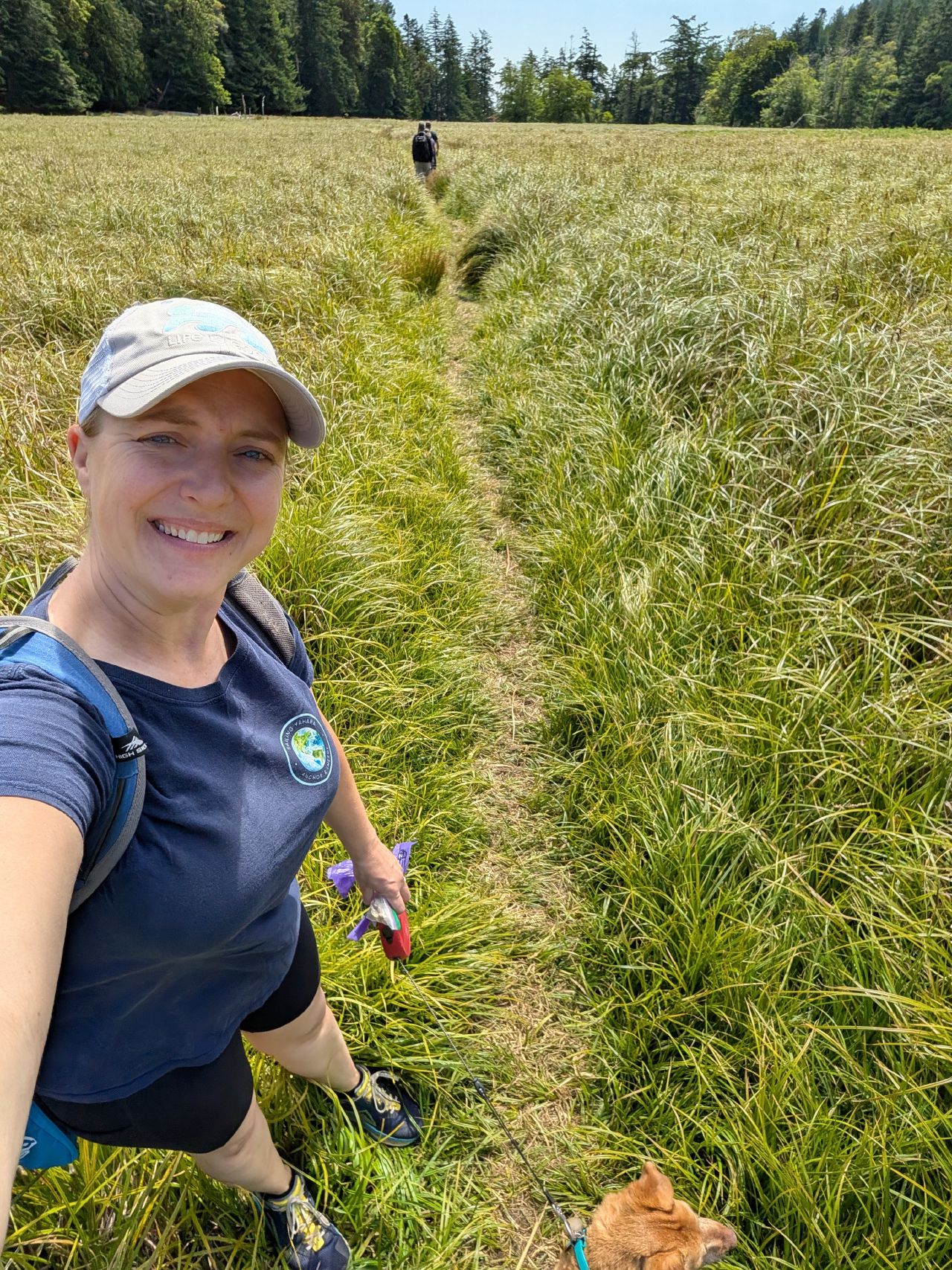 32% 41% Rachel hiking a narrow path through a grassy meadow