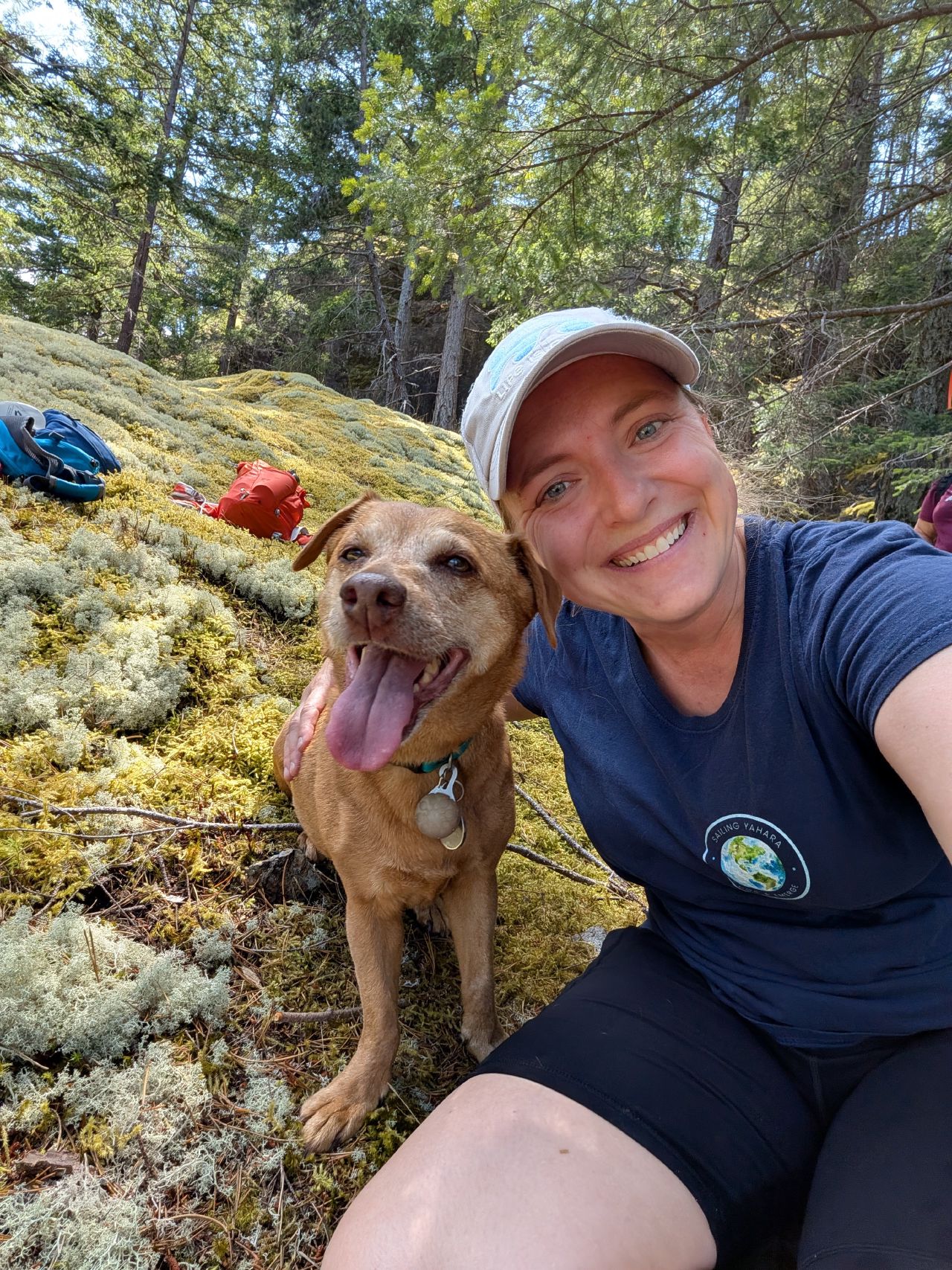 54% 46% Rachel and Maui resting in a mossy forest on the hike
