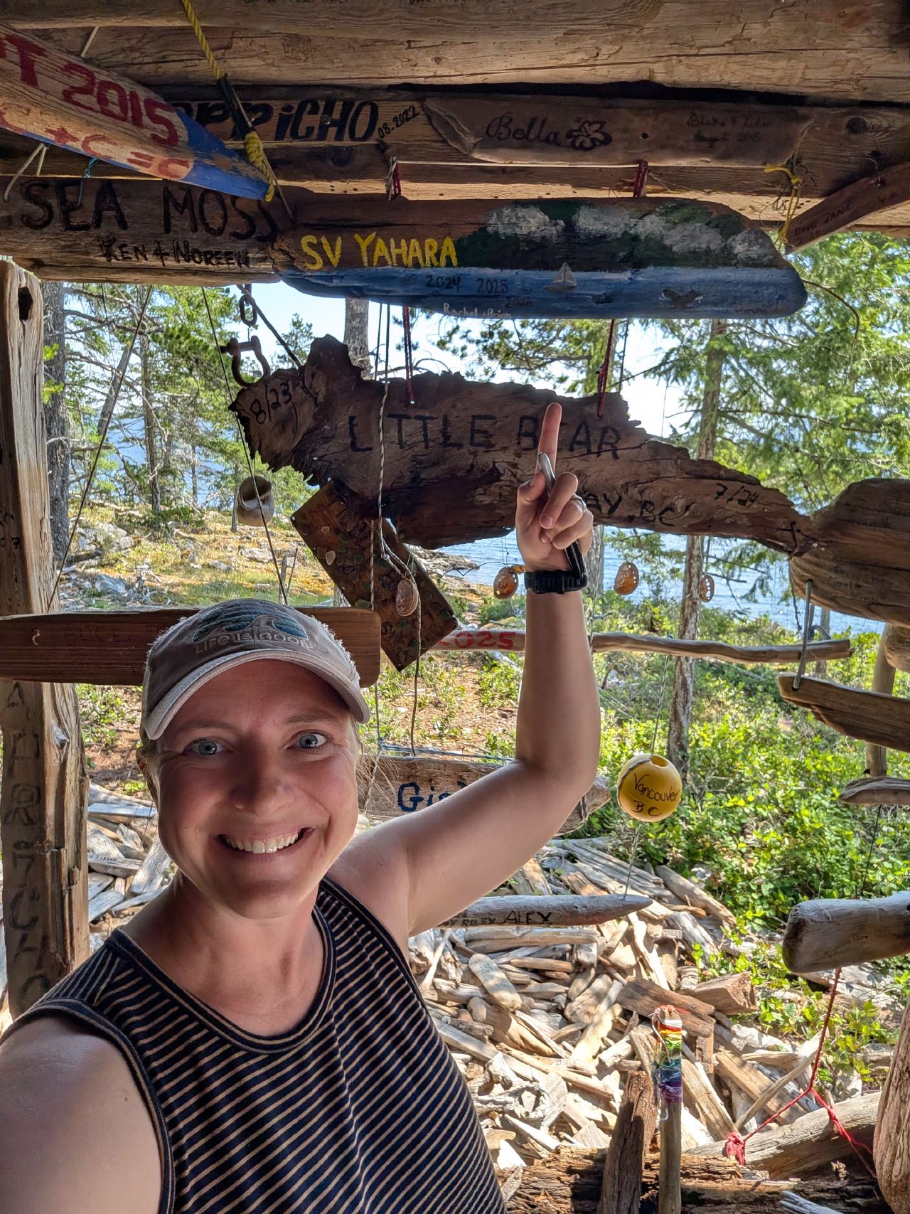 Rachel adding the SV Yahara sign to the driftwood shelter of boat names